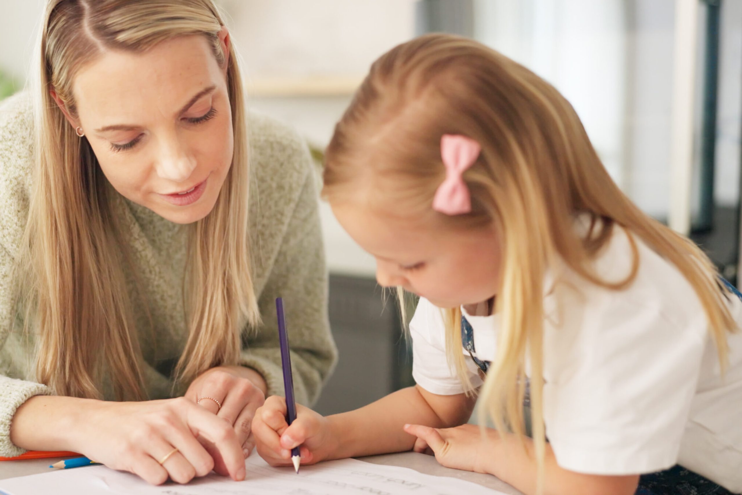 Education, mother and learning child writing or drawing for kindergarten school homework or project.